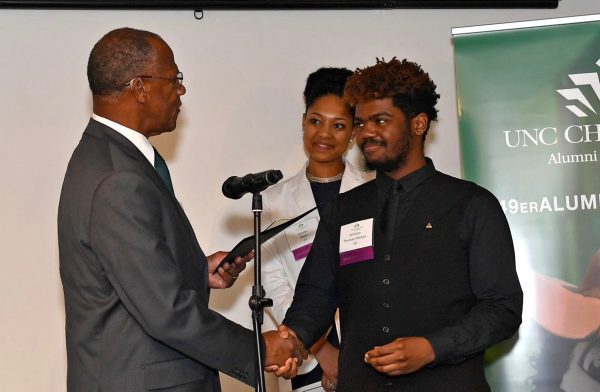 Thomas presenting awards to two students